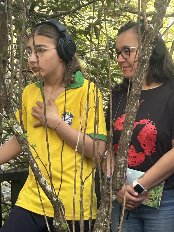 Visitantes utilizando equipos de amplificación y audífonos para escuchar los sonidos de los árboles y musgos en el Parque Omora en Puerto Williams